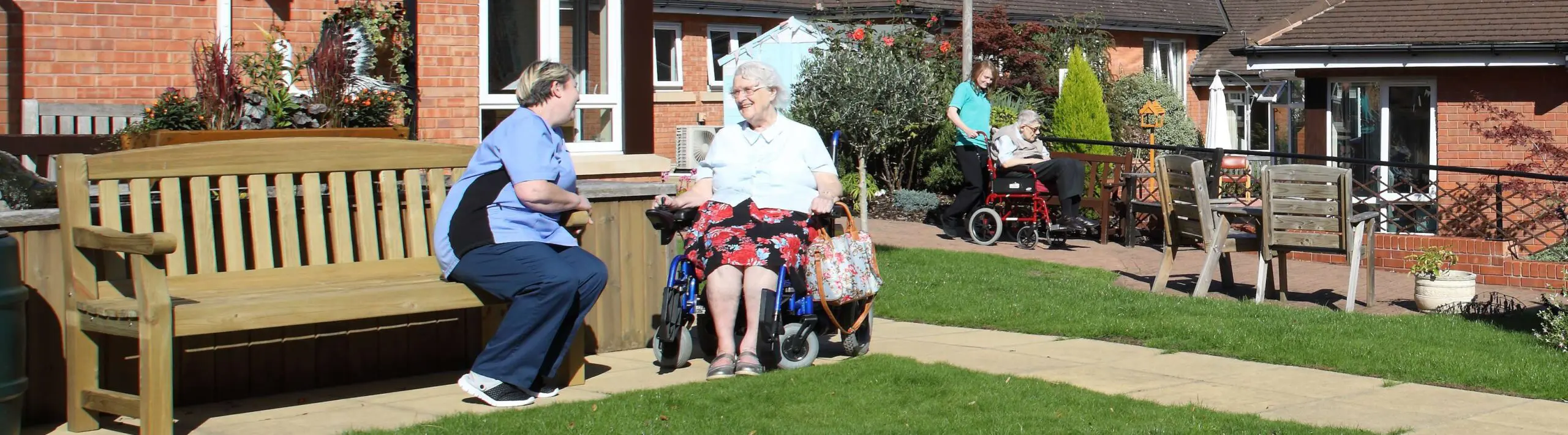 CCH Banner image showing a resident talking to a carer outside in our garden