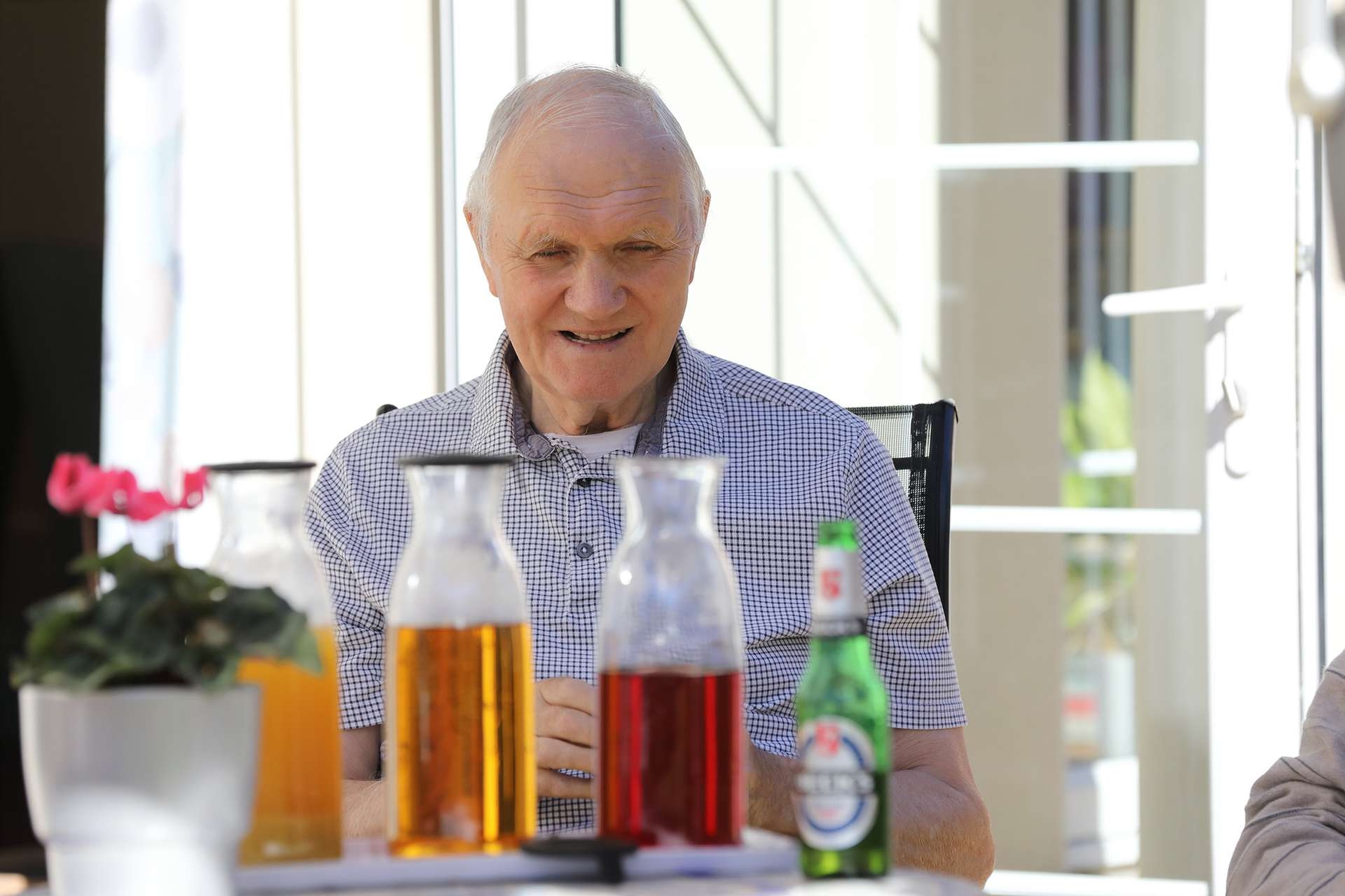 CCH Image showing a resident sat at a table with a variety of soft drinks