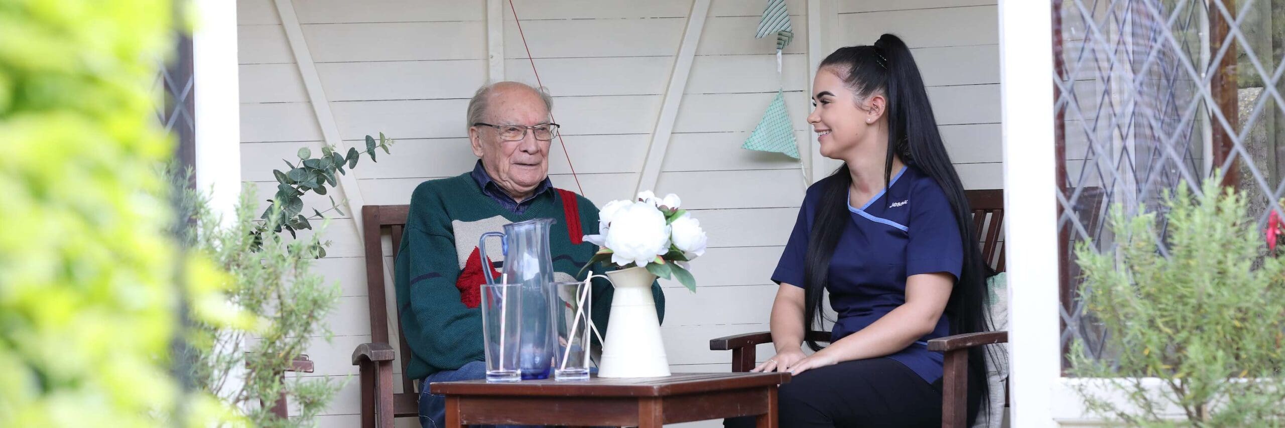 CCH Image showing a carer and resident enjoying time together outside in the garden